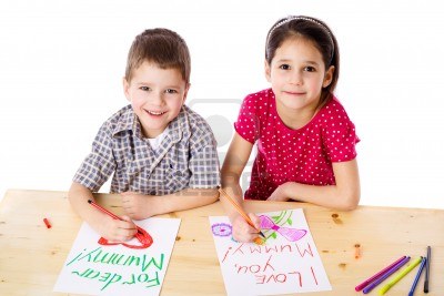 13248560-two-smiling-kids-at-the-table-draw-with-crayons-for-mum-isolated-on-white