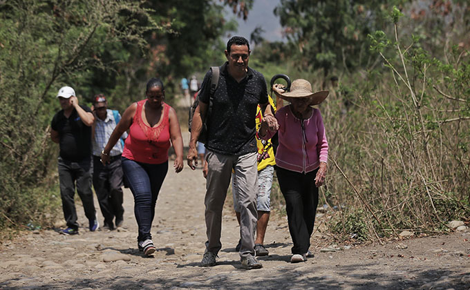 25 February 2019, Colombia, Cucuta: Venezuelans walk through unofficial rout on their way to Colombia after it closed all border crossings with Venezuela for 48 hours because of the damage had been caused by the clashes between demonstrators and Venezuela