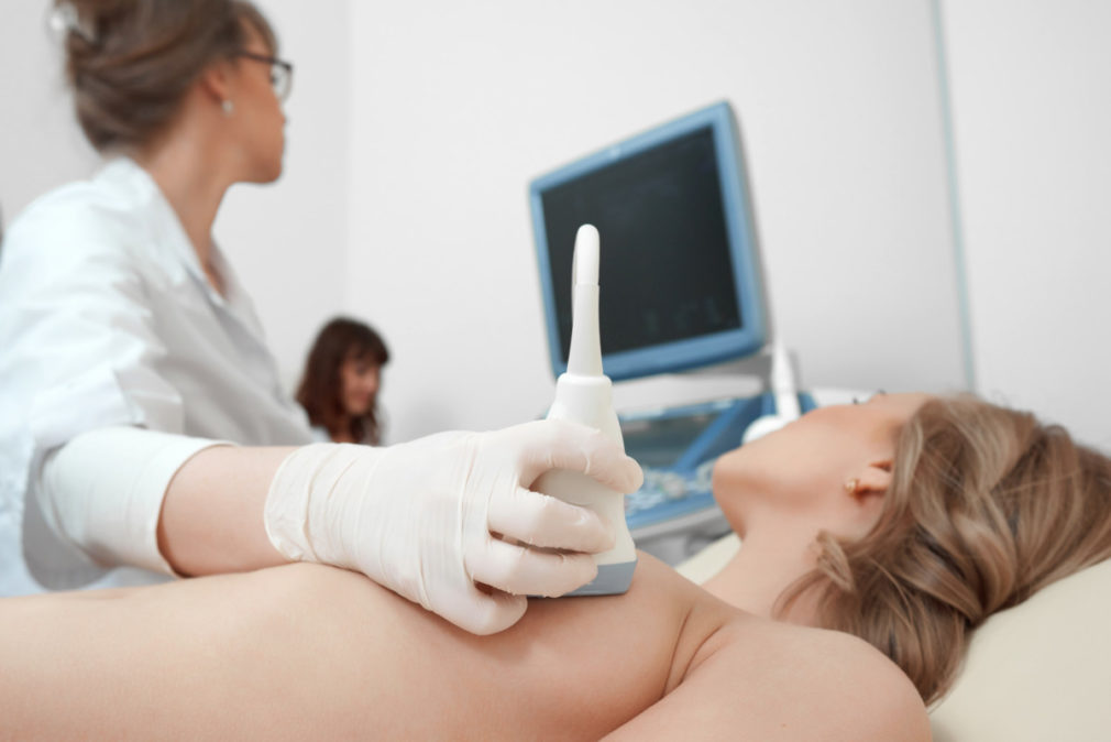 Young woman getting breast ultrasound scanning