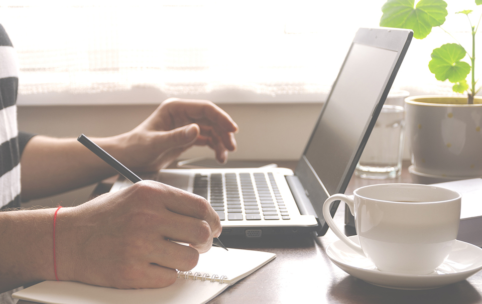 Freelancer works in the home office sitting at the desk near the window