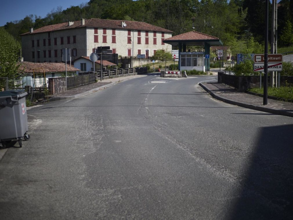 Un cartel señala la dirección a Francia mientras un policía interroga a un conductor en un control en la frontera navarro-francesa frontera Francia | Foto: EP