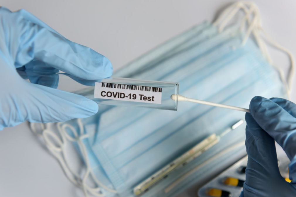 Hands in medical gloves holding COVID-19 swab. Test tube for taking patient sample, PCR DNA testing protocol process. Nasal swab laboratory test in hospital lab.