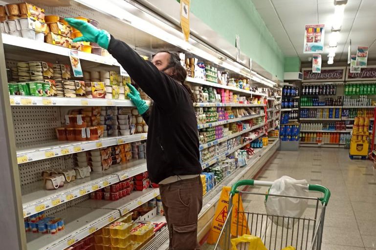 un operario municipal del Ayuntamiento de Cúllar Vega realiza la compra en un supermercado local para un vecino en cuarentena por coronavirus