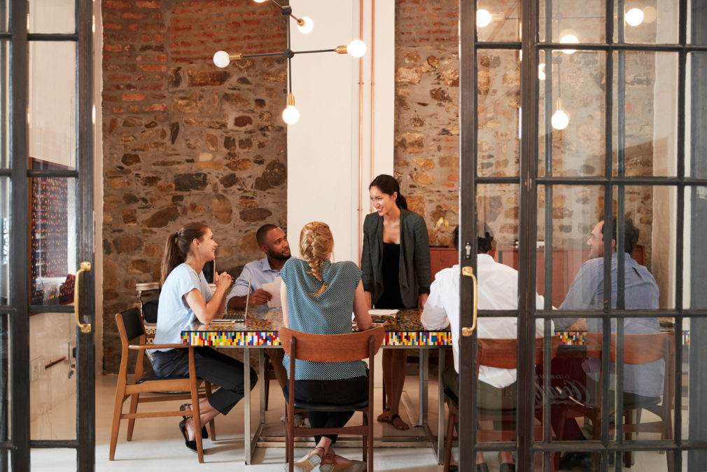 Female boss addressing business team in a meeting room