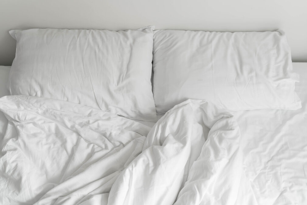 rumpled bed with white messy pillow decoration in bedroom