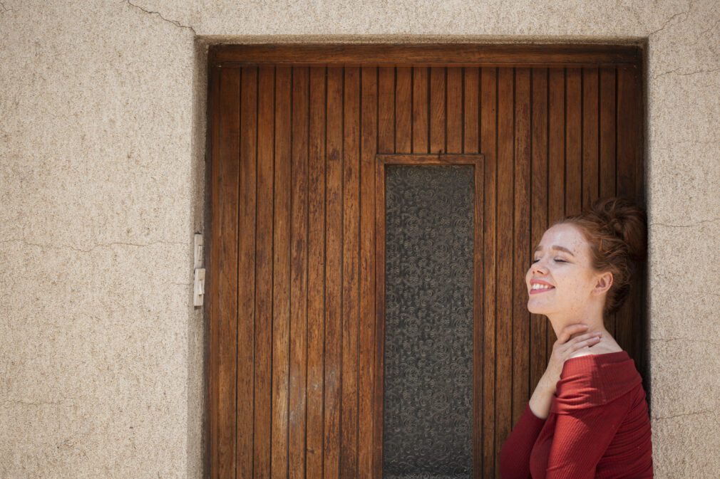 young-redhead-woman-posing-front-door