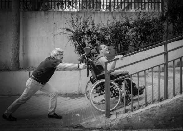 Una persona con parálisis cerebral es empujada en su silla de ruedas | Foto: E. P.