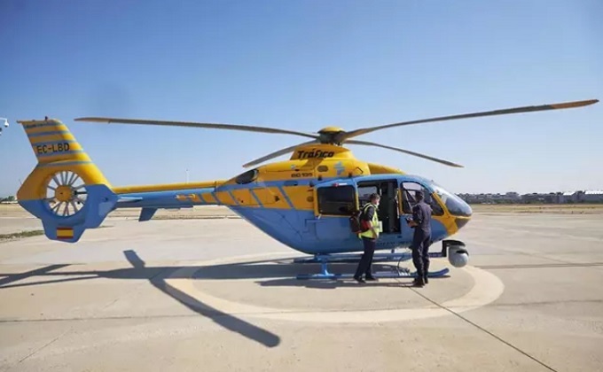 Un operario y un militar tras el aterrizaje de uno de los helicópteros Pegasus de la DGT - Foto Jesús Hellín - Europa Press
