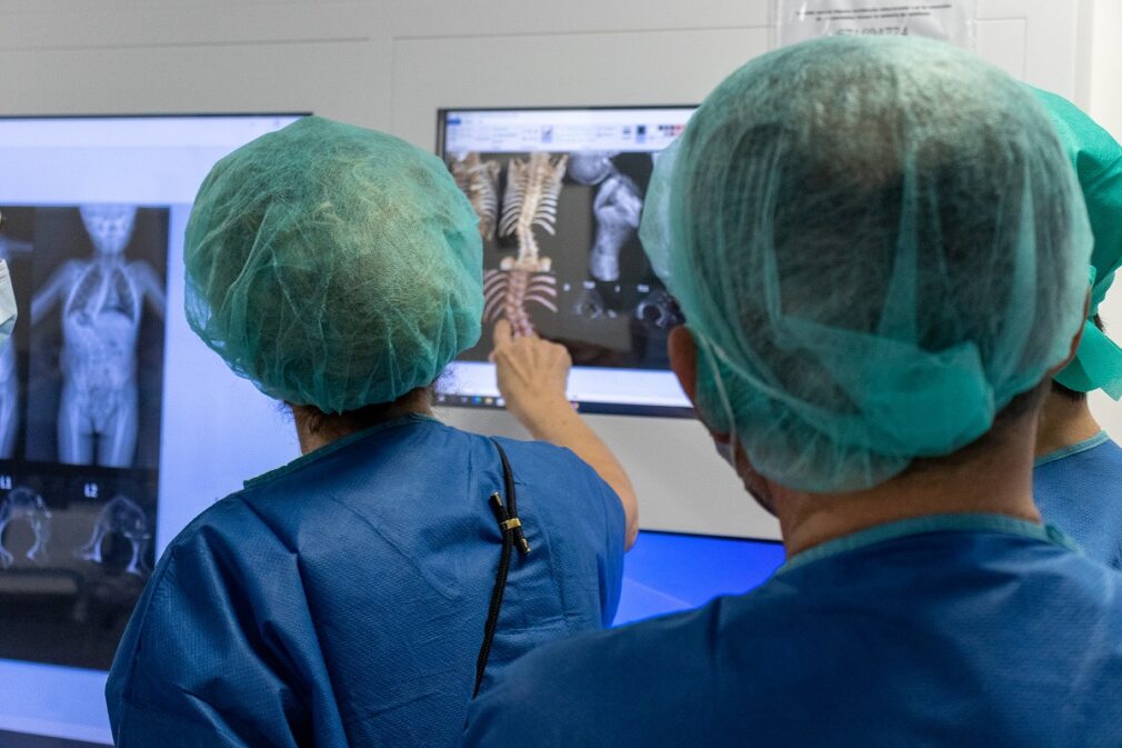 Cirujanos revisan la imagen de la columna del paciente.jpg