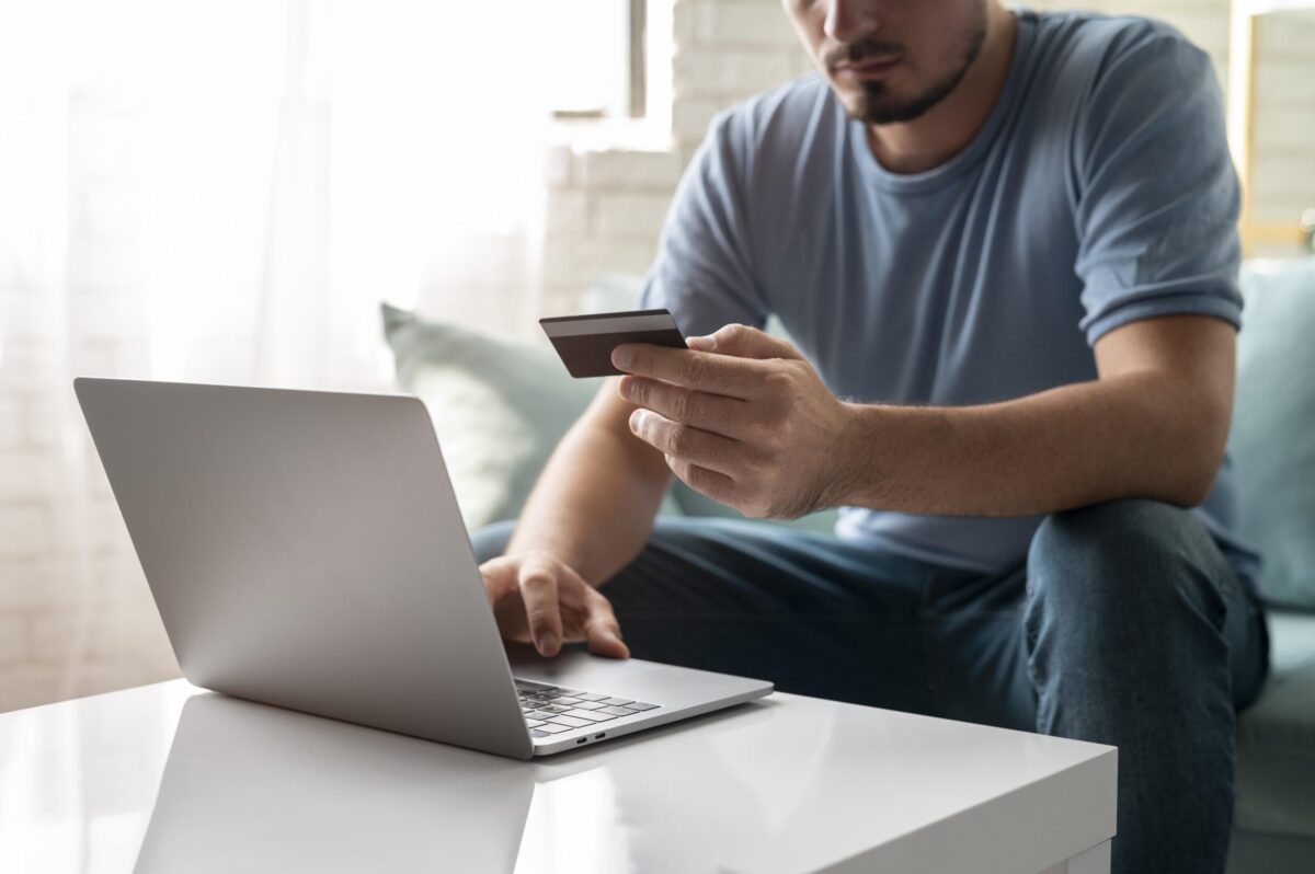 hombre-usando-su-tarjeta-de-credito-para-jugar-en-linea-para-un-pedido